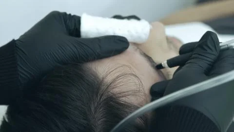 Close up of cosmetologist making permanent makeup. Microblading procedure. Stock-Fotos