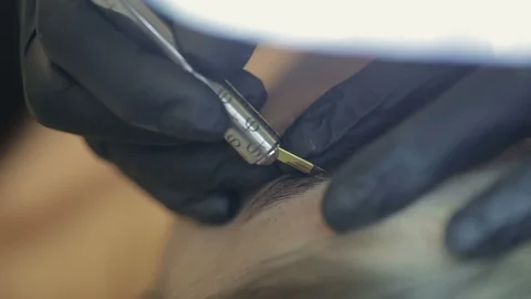 Close up of cosmetologist making permanent makeup.Microblading procedure. Video stock 87411430