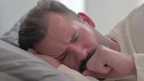 Close up of Coughing Man Lying on Side in Bed Stock Footage 287899501