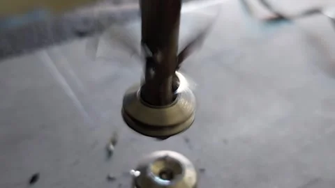 Close-up of a countersink drill bit spinning and cutting a metal washer with met Vídeos de archivo 336484591