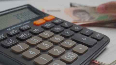 Close up counting money with a calculator on table Stock Footage 276519443
