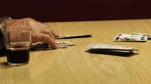 Close up, counting the points of the match, we see a hand of elder playing cards Stock Footage 87684772