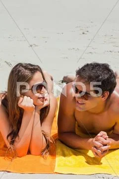 Close-up of a couple being tanning on the beach Stock Photos