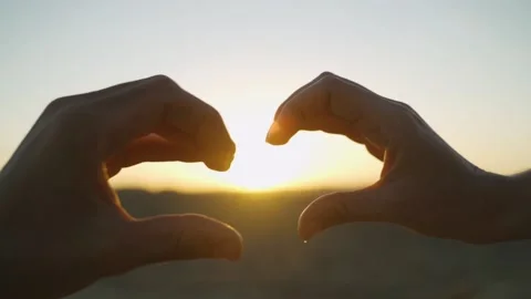 Close up couple doing love or heart hand gesture - desert sunrise in background Stock Footage 140550384