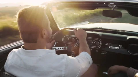 Close up of couple driving classic cherry red convertible, cabriolet car, at sun Stock Footage 199632421
