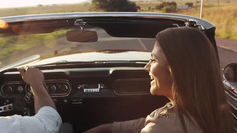 Close up of couple driving classic cherry red convertible, cabriolet car and tur Stock Footage 199632426