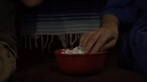Close up of a couple eating popcorn while watching TV Stock Footage 157396818