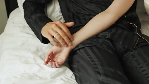Close-up of a couple gently touching hands in their cozy bed on a white bed Stock Footage 312881442