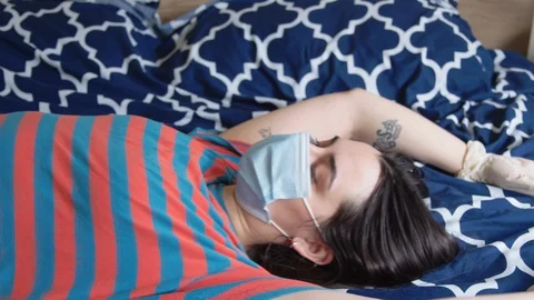 Close up - couple gets steamy in bed with masks and gloves on Stock Footage 129896060