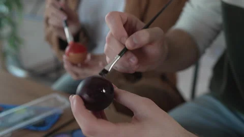 Close up on couple hands hands paint decorative easter egg in living room Stock Footage 301916295