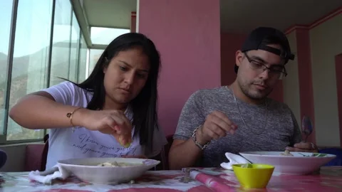 Close-up of a couple having soup in an Andean restaurant with mountains in the b 库存影片 198760976