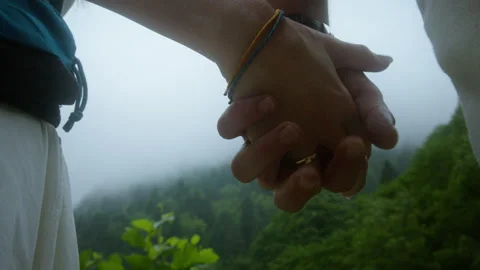 Close-up of couple holding hands during outdoor hike, symbolizing love, con.. Stock Footage 314477000