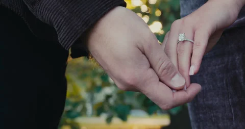Close-up couple holding hands with ring, large diamond ring visible on womans Video stock 321621160