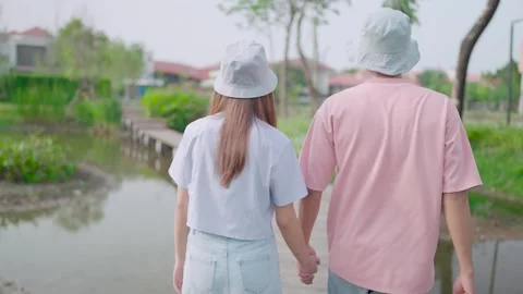 Close-up of a couple holding hands while walking through the backyard,  Stock Footage 265052506