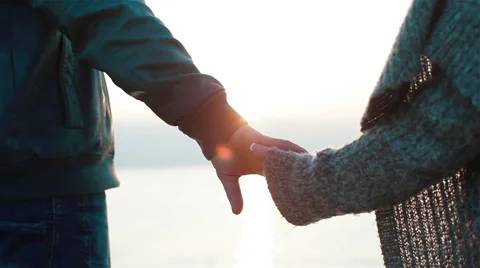 Close up of couple holding hands. Young couple in love coming closer to see sea Stock Footage 50137869