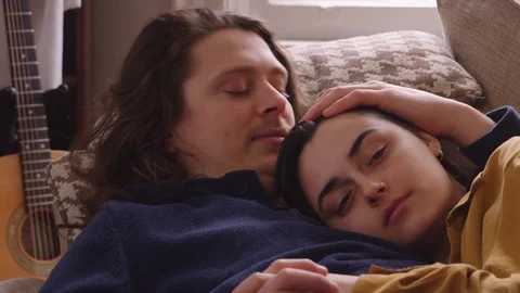 Close up couple lying down on a couch relaxing and watching TV. - slow motion Stock Footage 129466647