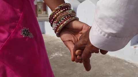Close up of a couple's hands with bangles and traditional Indian clothes Stock Footage 70340336