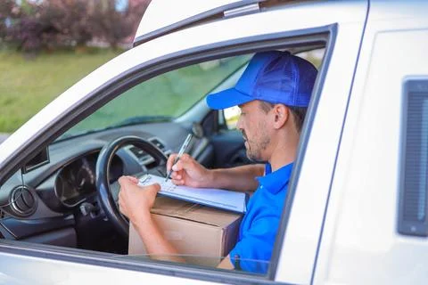 Close-up courier with boxes in a white van preparing to leave for orders Foto stock