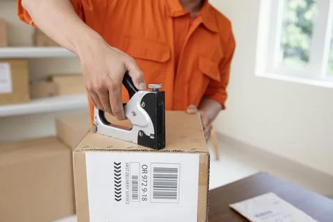 Close up on courier preparing package for delivery Stock Photos