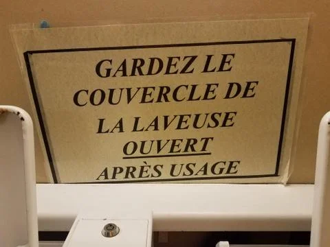 Close the cover of the laundry machine when done sign in French Stock Photos