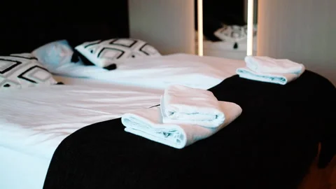 Close up of cozy bed with decorative geometric pattern pillows and white sheets. Stock Footage 340341800