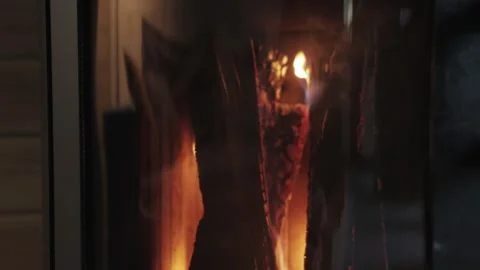 Close-up cozy house chimney fire place fire burning in a tiny house, wooden wall Stock Footage 256982816