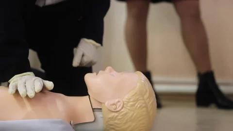 Close-Up of CPR Training on a Dummy with Chest Compressions. Woman trans Stock Footage 280010879