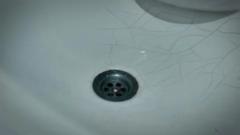 Close-up of Cracked Ceramic Sink and Metal Drain Hole 動画素材 337483880
