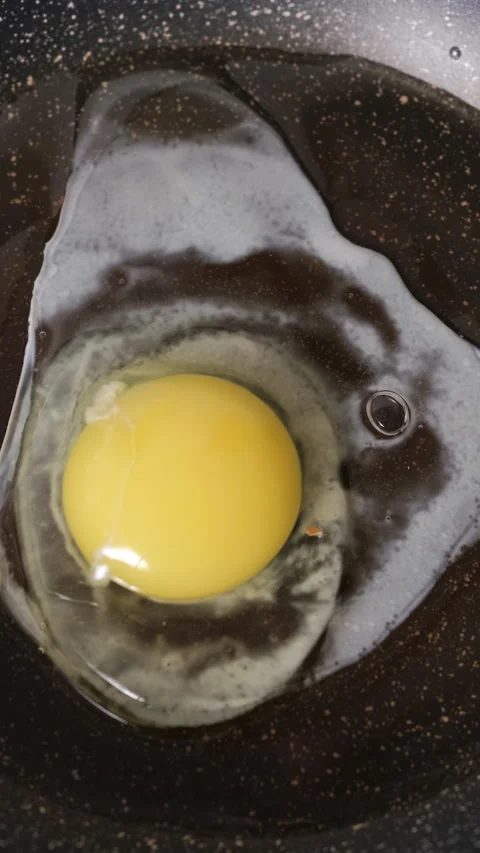 Close-up of cracking eggs on pan frying Vídeo Stock 322219421