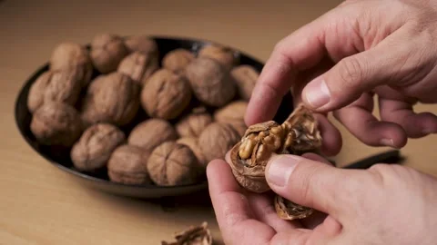 Close Up of Cracking Walnut with Nutcracker on Wooden Table Vidéo 331531311