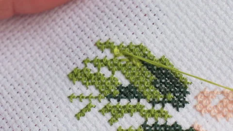 Close Up Crafter Passing Needle with Green Thread on Cross Stitch Vidéo 322669995