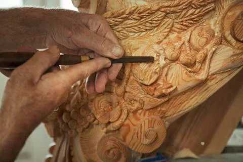 Close up of a craftsman at work, using a fine chisel to shape and chisel out the Stockfoto's