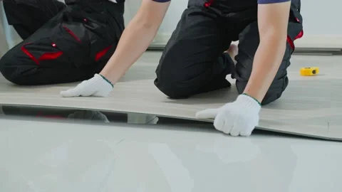 Close up of Craftsman worker installs laminate board on floor at home. Stock Footage 170878308