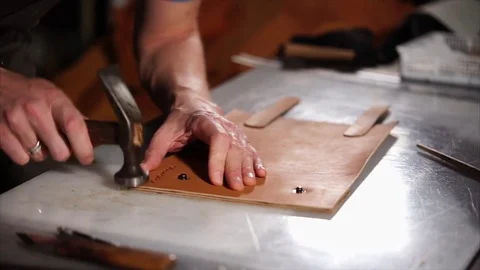 Close up of a craftsman working with leather using hammer Stock Footage 81682279