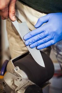 Close up of a craftsman in a workshop, sharpening and honing the blade of a 스톡 사진