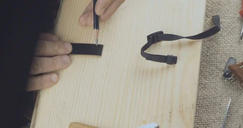 Close-Up Of A Craftsman's Hand Marking A Strip Of Leather With A Pencil Stock Footage 121588402