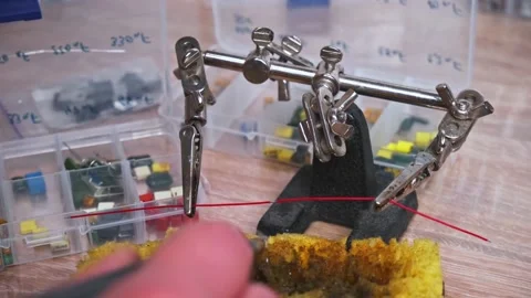 Close-up of a craftsman's hand soldering two wires. The soldering process in  Stock Footage 130779502