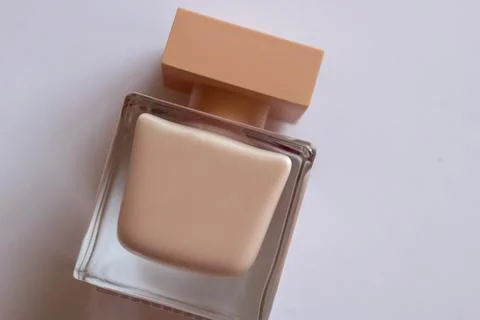 Close-up of cream-colored eau de Parfum. Close-up photo on a white background Stock Photos