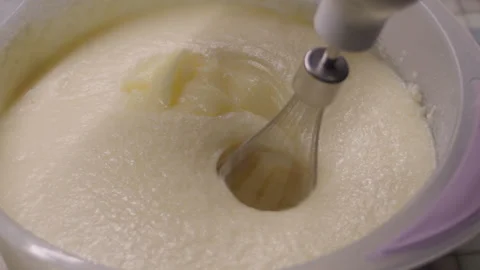 Close-up, cream ingredients falling into a plastic bowl and whipping with a Stock Footage 337122286