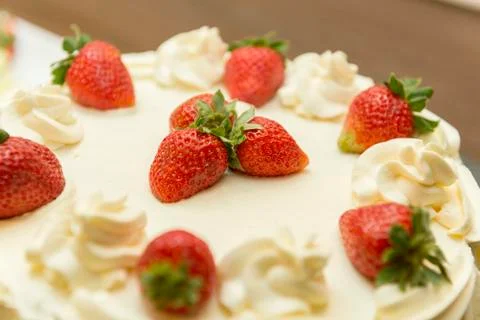 Close up of creamy white chocolate cake with strawberry slices. Stock Photos