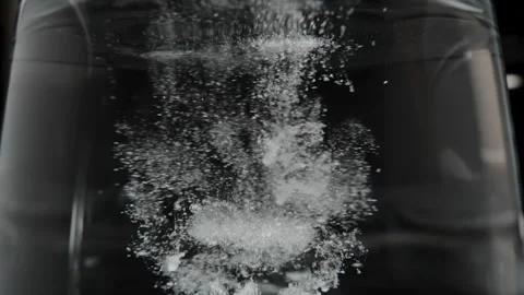 Close-up of Creatine powder dissolving in water, forming clumps as it begins to Stock Footage 283783588