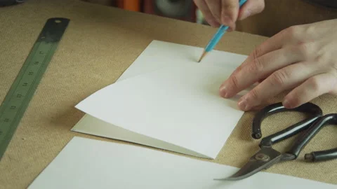Close-up of creating patterns for the production of handmade clothing. A hand Stock Footage 143726971
