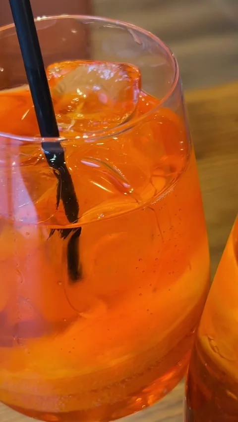 Close-up of the creation of a refreshing orange cocktail aperol spritz with ice Stock Footage 317908432