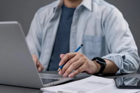 Close up creative designer man holding pencil and working on laptop compute.. Stock-Fotos
