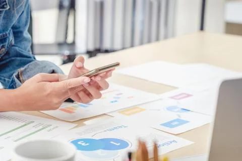 Close up creative director use mobile phone at desktop table at office when p Stock Photos