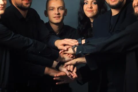 Close up. creative group of young people folded their hands together Stock Photos