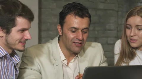 Close up of a creative team collaborating on a laptop in a modern office Stock Footage 311990967