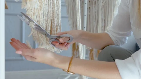 Close-up creative woman scissors cuts ends of macrame Stock Footage 120982710