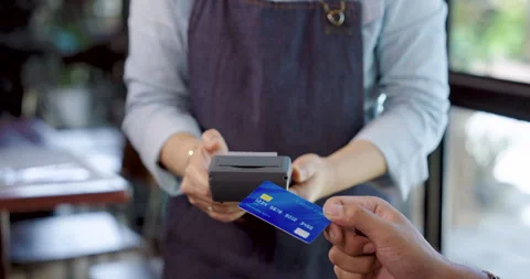 Close up credit card payment between customer and elderly cafe owner in apron Stock Footage 320242627