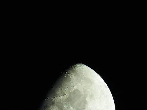 A close-up of the crescent moon with its moon craters Foto stock